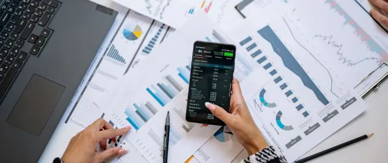 Comparing debt consolidation options Comparing finances at a desk with a phone, charts and notes